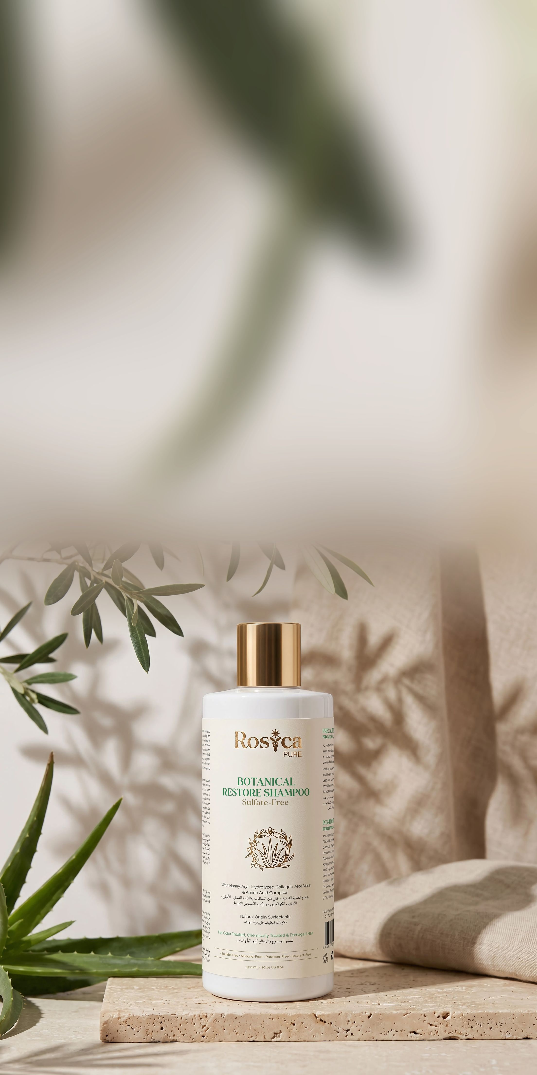 Rosica Pure Botanical Restore Shampoo on travertine with olive branches and aloe vera